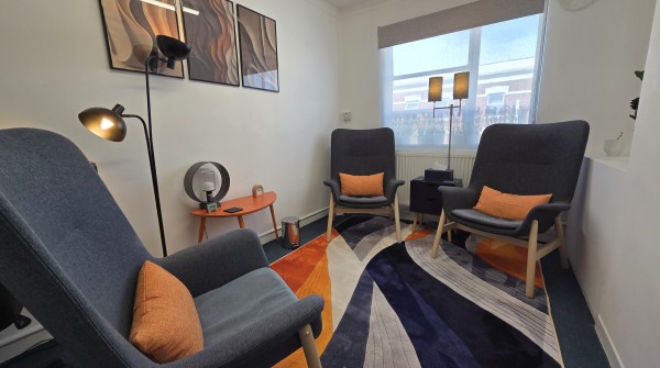Calm, softly lit therapy consulting room with two armchairs at Space To Be You in Hackney